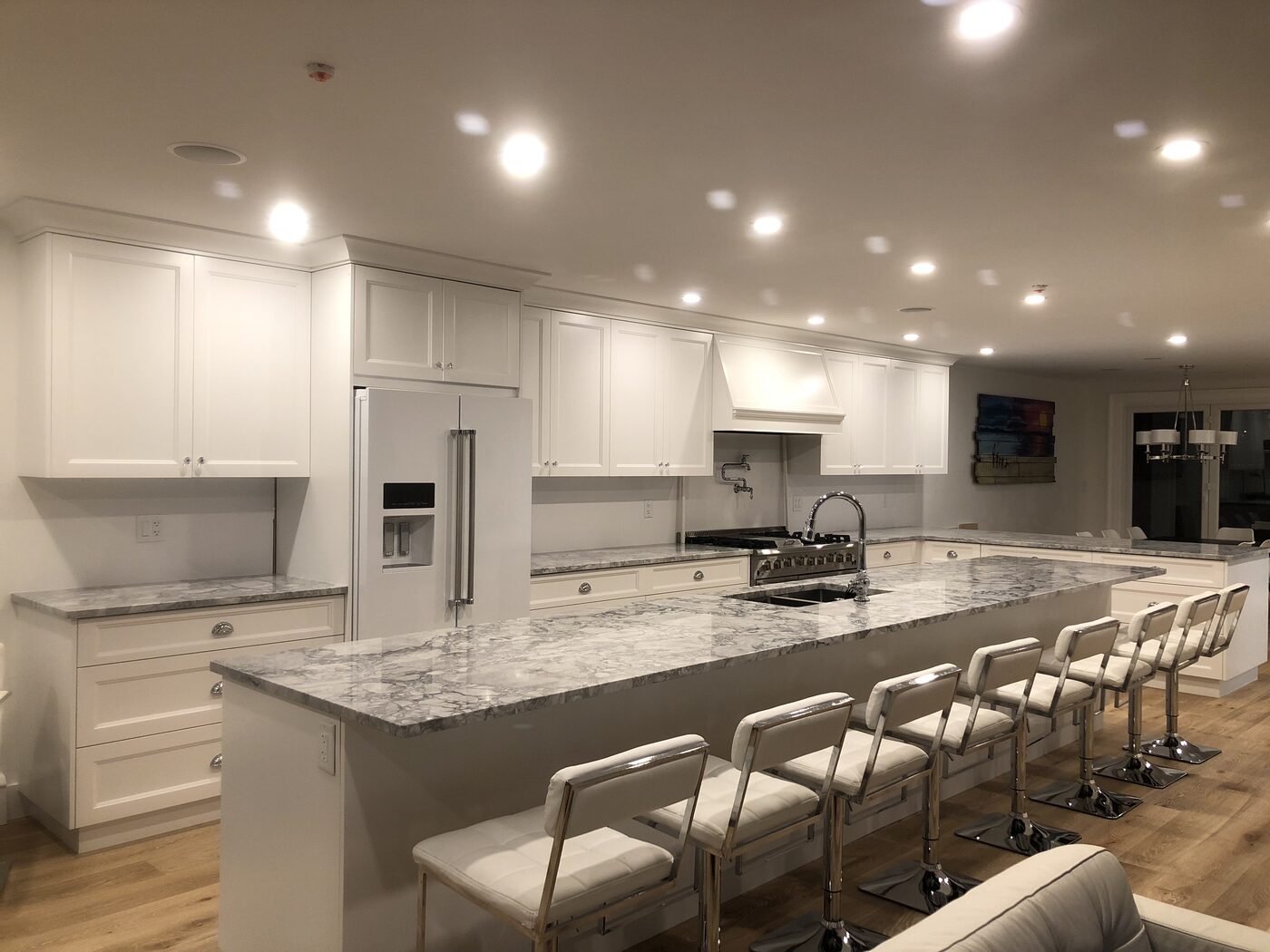A completed Top Tier Builders kitchen renovation — custom white cabinetry and a marble waterfall island